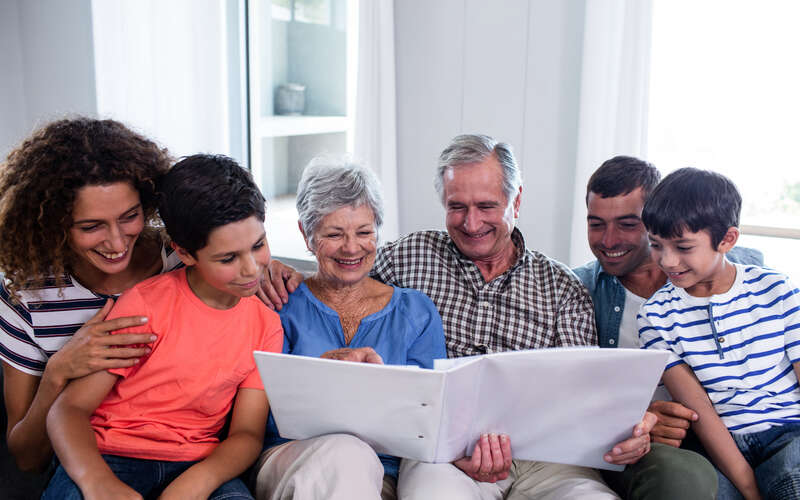 multi-generational family looks through notebook