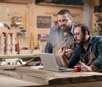 Dva poslovneža v svoji delavnici preverjata kritja, ki jih nudi njuno zavarovanje