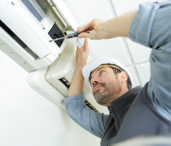 Monter klimatske naprave med namestitvijo notranje enote na steno dnevne sobe.