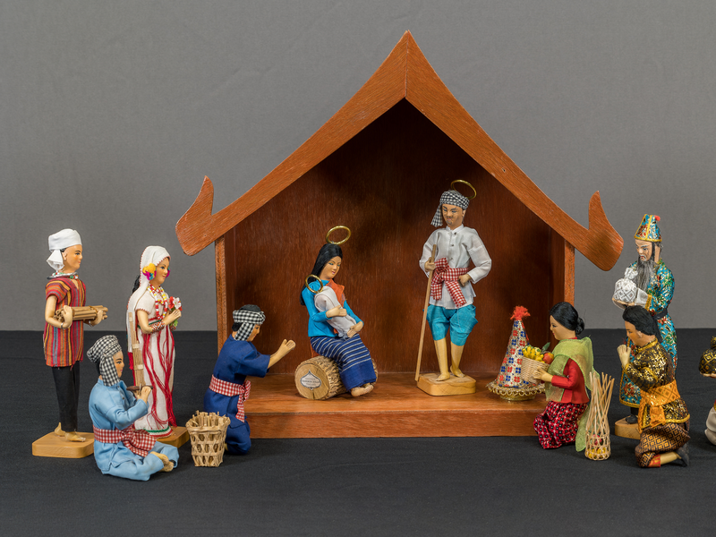 Thai crèche with a stable, the Holy Family & 8 people in traditional Thai clothing. The 8 people are merchants, farmers, nobility, & the Karen people.