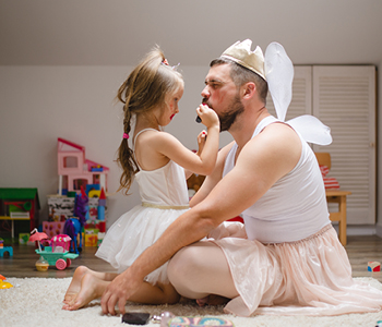 Fotografija hčerke, ki šminka očeta in se z njim igra domišjijsko igro - Simbolna fotografija za predloge skupnih aktivnosti očka z otrokom