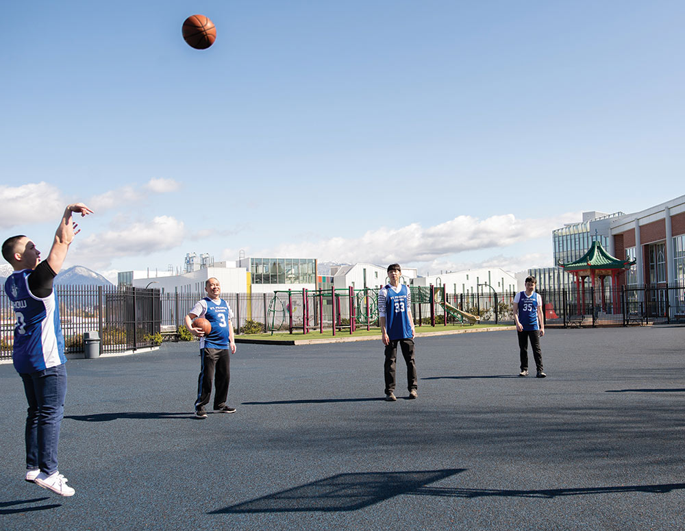 Anthony Chow takes a jump shot on the basketball court outside