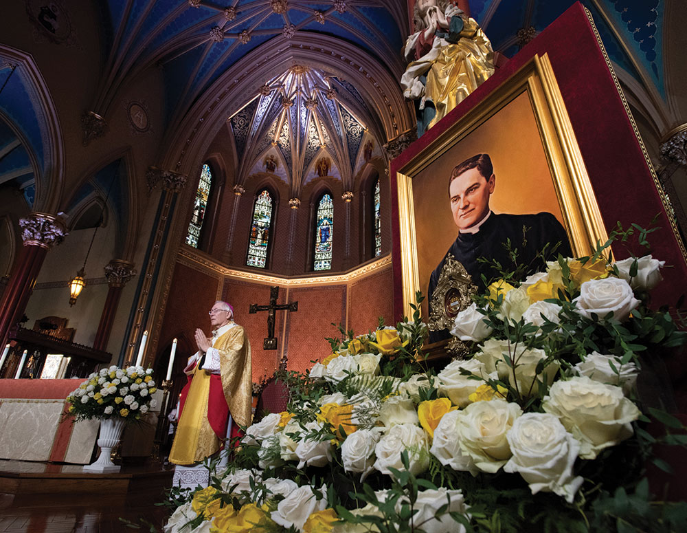 A portrait of Blessed Michael McGivney adorns the sanctuary as Archbishop Blair leads the congregation in prayer. Photo by Jeffrey Bruno
