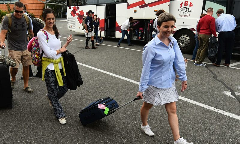 Warriors to Lourdes staff getting off shuttle bus with their luggage.