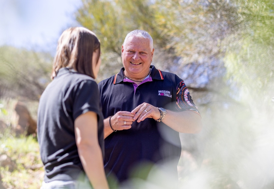 Paul Royce, Regional Leader for NT, talking to a young woman in an outdoor setting.