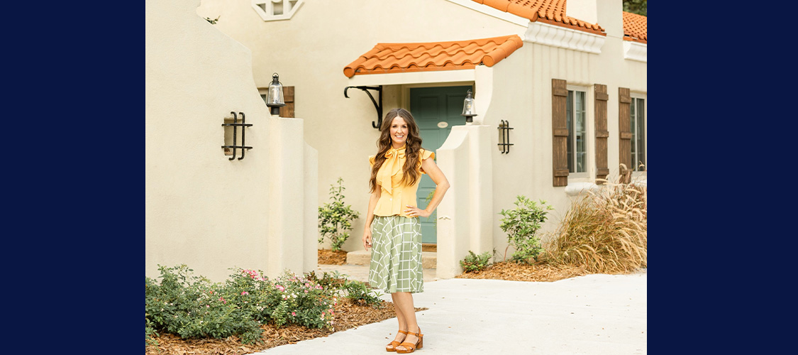 Sara McDaniel standing outside of a pretty house.