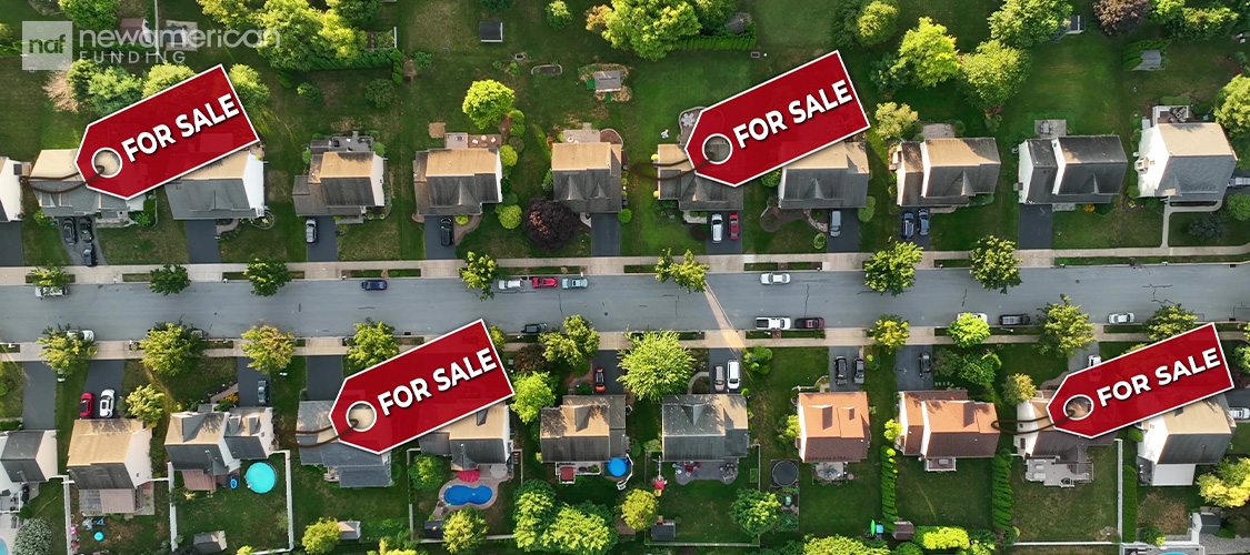 An aerial shot of a residential neighborhood with for sale signs on them.