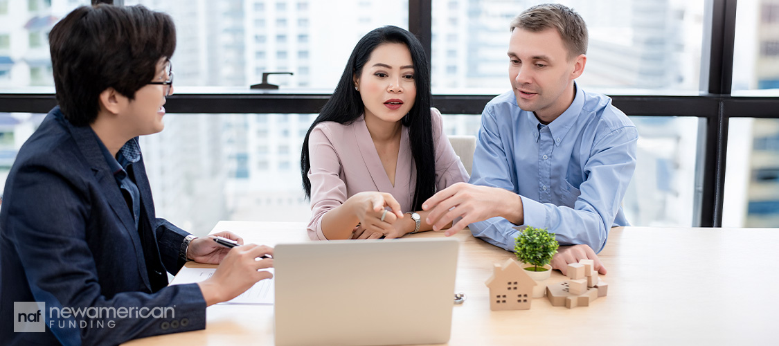 A couple meeting with a loan officer in an officer.