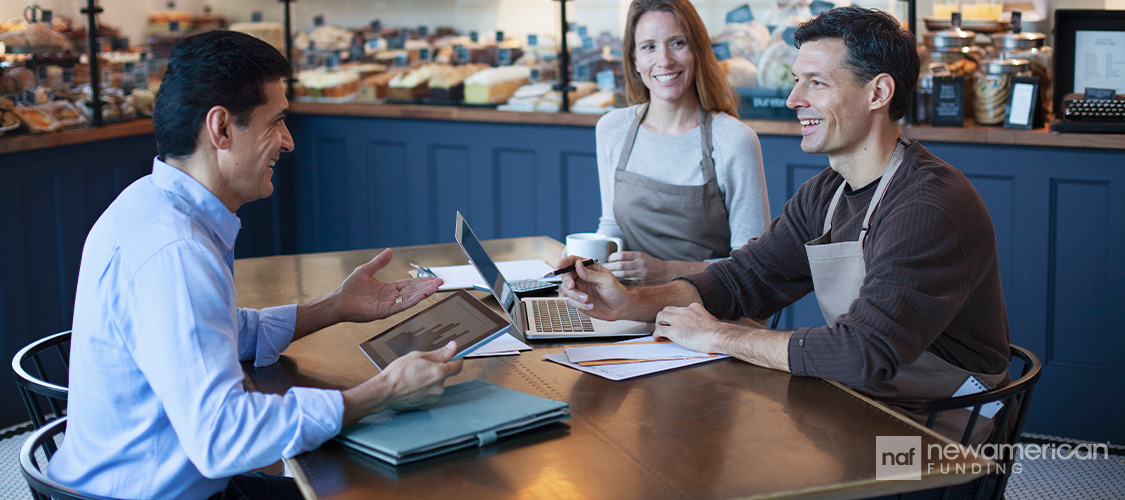 Two business owners meeting with a loan officer.
