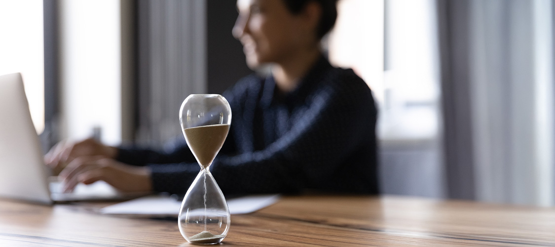Man sitting next to an hourglass
