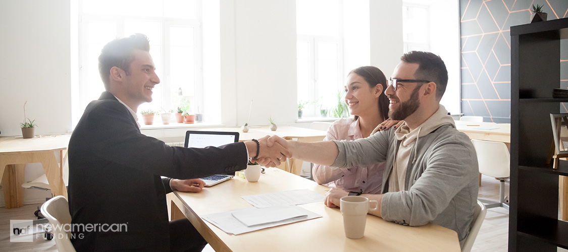 A couple shaking hands with a loan officer.