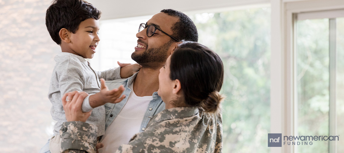 Parents in military uniform holding up a small child.