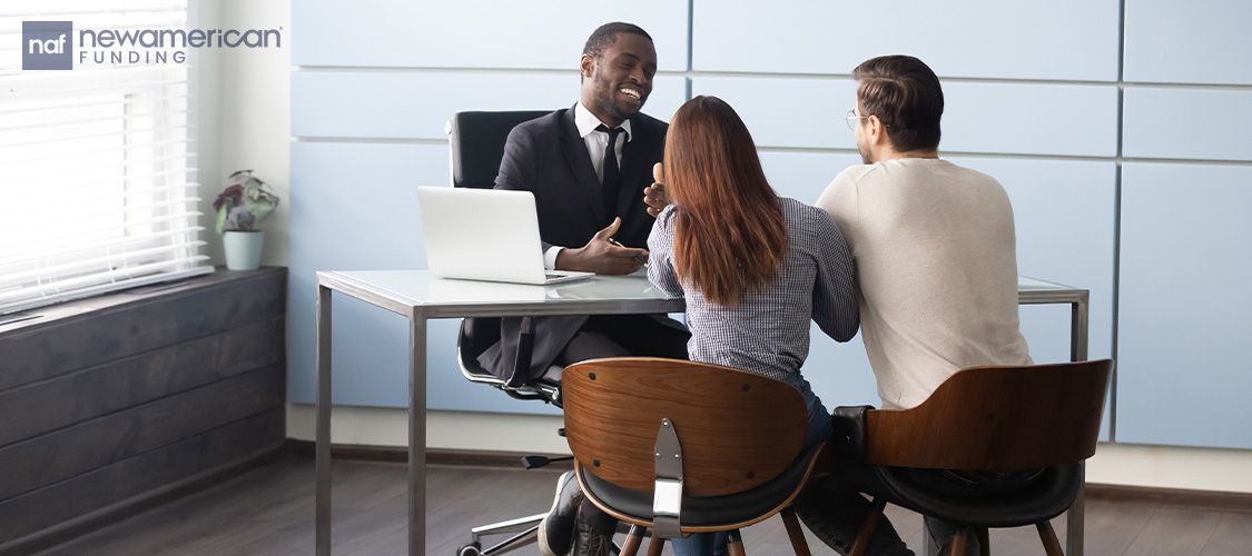 A couple meeting with a loan officer in an office.