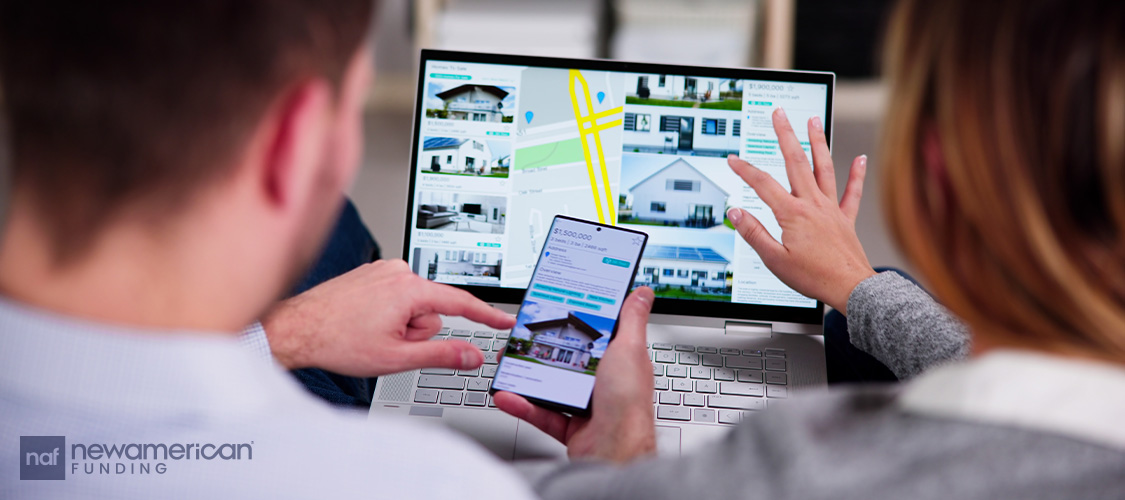 A couple scrolling home listings on a laptop as well as a phone.