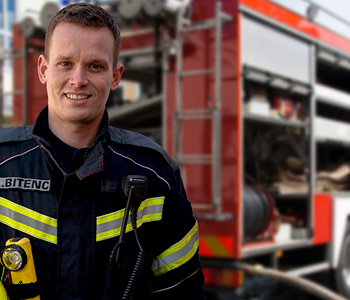 Poklicni galsilec Anže Bitenc pred gasilskim tovornjakom