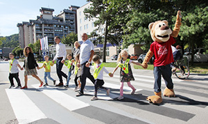 Skupina otrok s predstavniki zavarovalnice Generali in Generalijevo maskoto na 3D zebri.