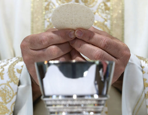 Priest breaking holy communion