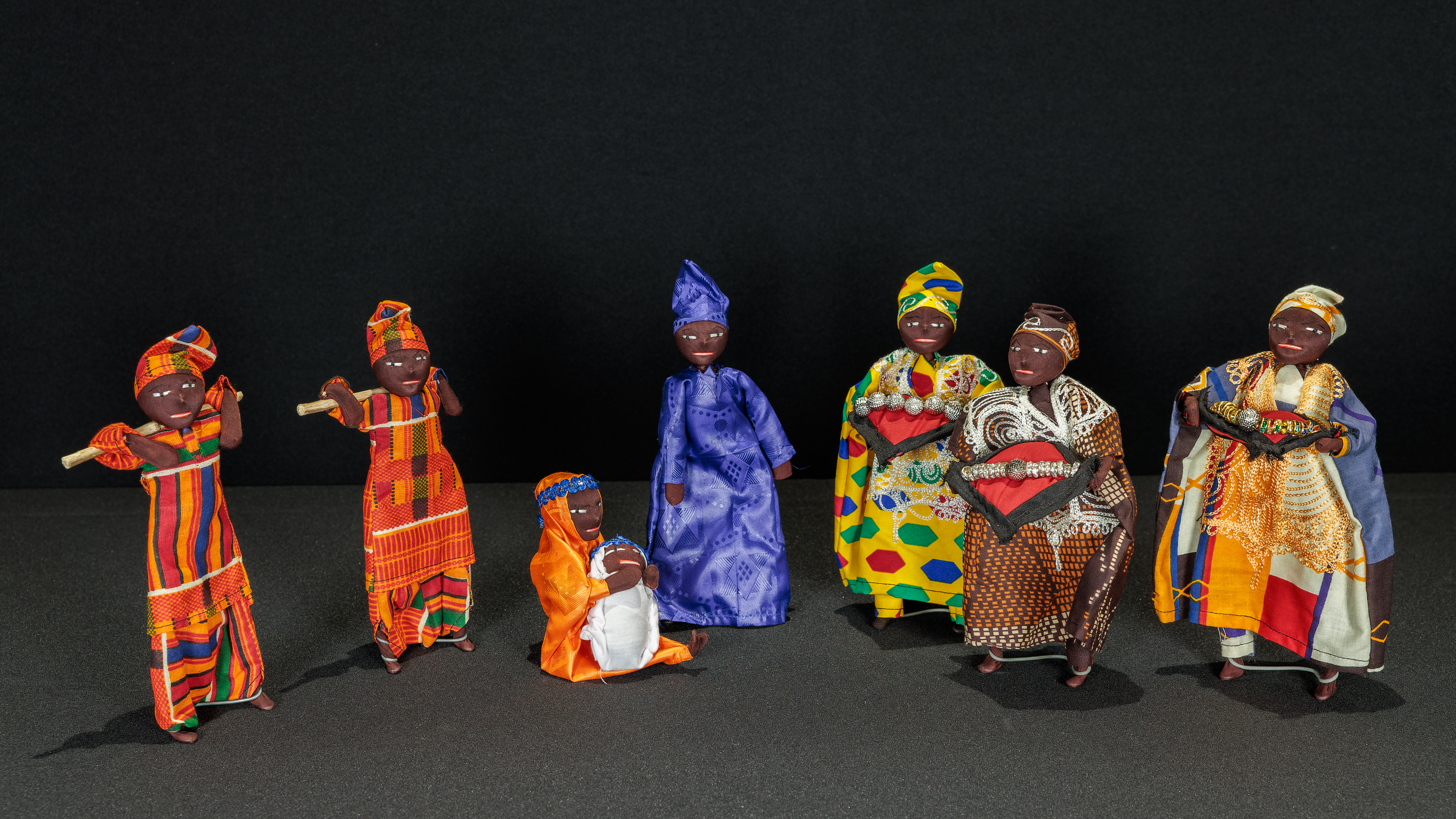 Nativity scene from Senegal featuring Mary holding the Christ Child, Joseph, two shepherds, and the Magi made of wire and dressed with batik fabric.