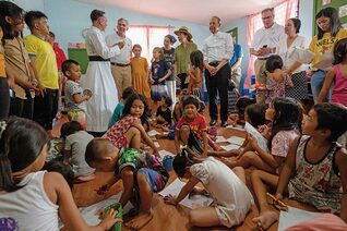Father Matthieu Dauchez (in white cassock), director of the ANAK-Tulay Ng Kabataan Foundation, speaks to the K of C delegation during their visit to one of the foundation’s day care centers in the Aroma neighborhood of Tondo, Metro Manila, on Aug. 21.