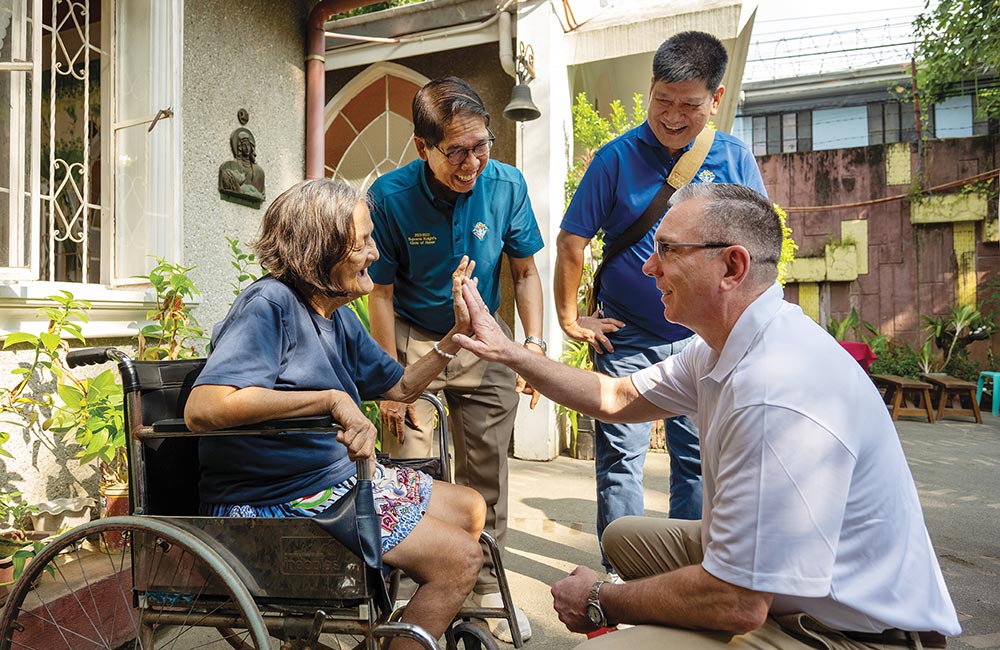 Supreme Master Michael McCusker (right) greets a resident of Sts. Louis and Zelie Martin Home for Elders, run by the ANAK-Tulay Ng Kabataan Foundation, on Aug. 21.