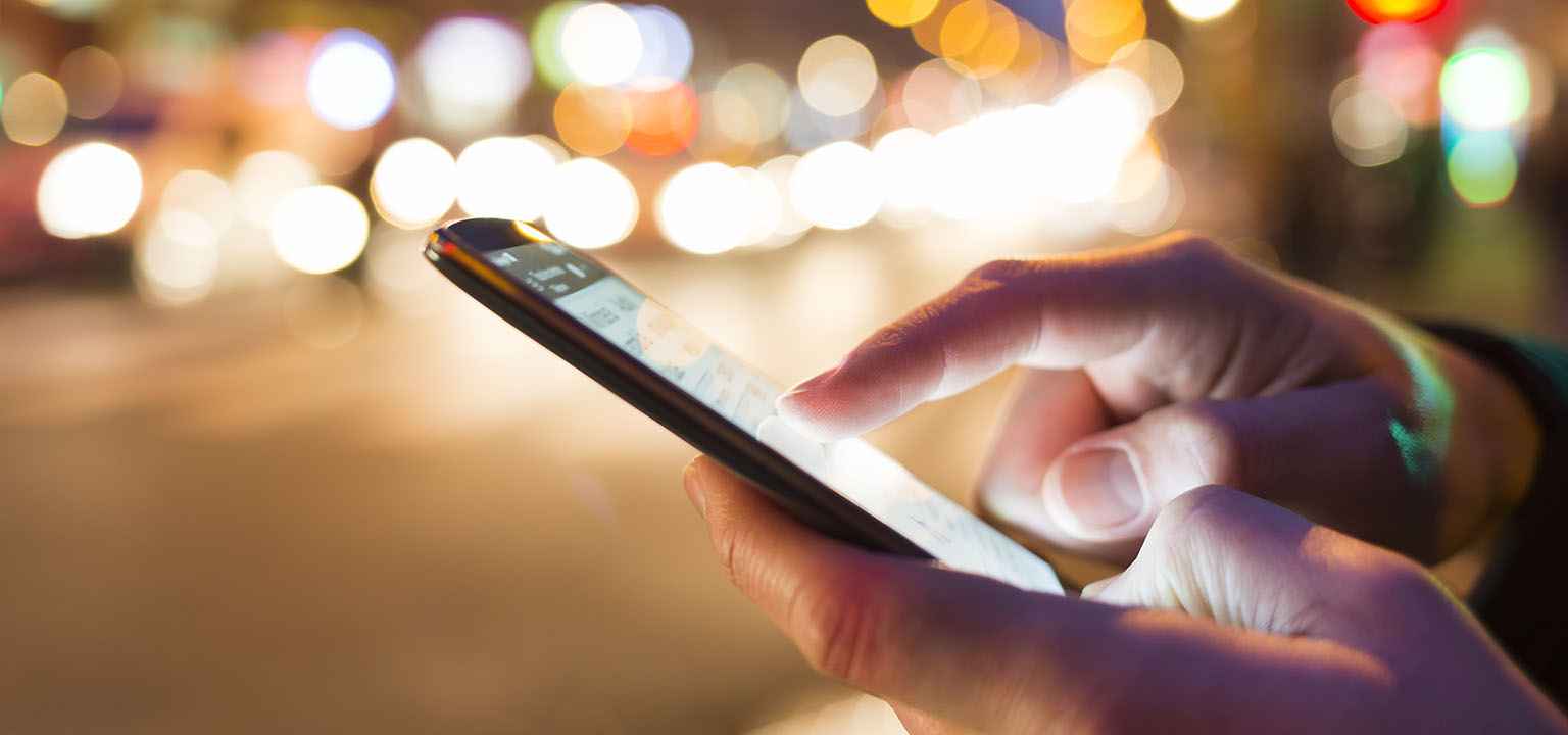 Close up photo of a persons hands interacting with their smart phone. 