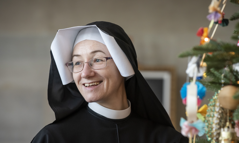 A portrait of Sister Inga Kvassayova, ISMM, standing next to a Christmas Tree.