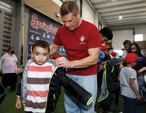 Steven Bishop of Holy Spirit Council 9533 in Springfield, Mo., helps a boy try on a jacket at a Knights of Columbus Coats for Kids event