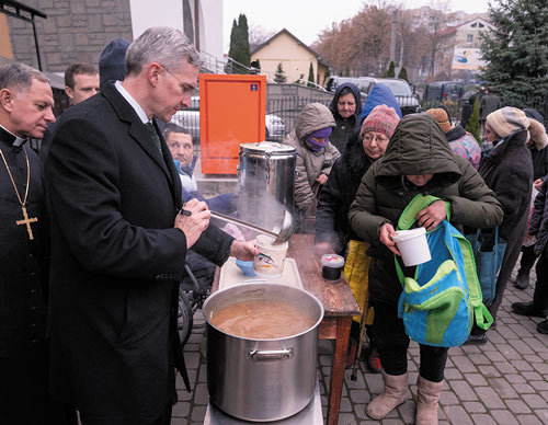 Alongside Archbishop Mieczysław Mokrzycki, Supreme Knight Kelly serves soup at a shelter operated by the Albertine Brothers in Lviv, Ukraine.
