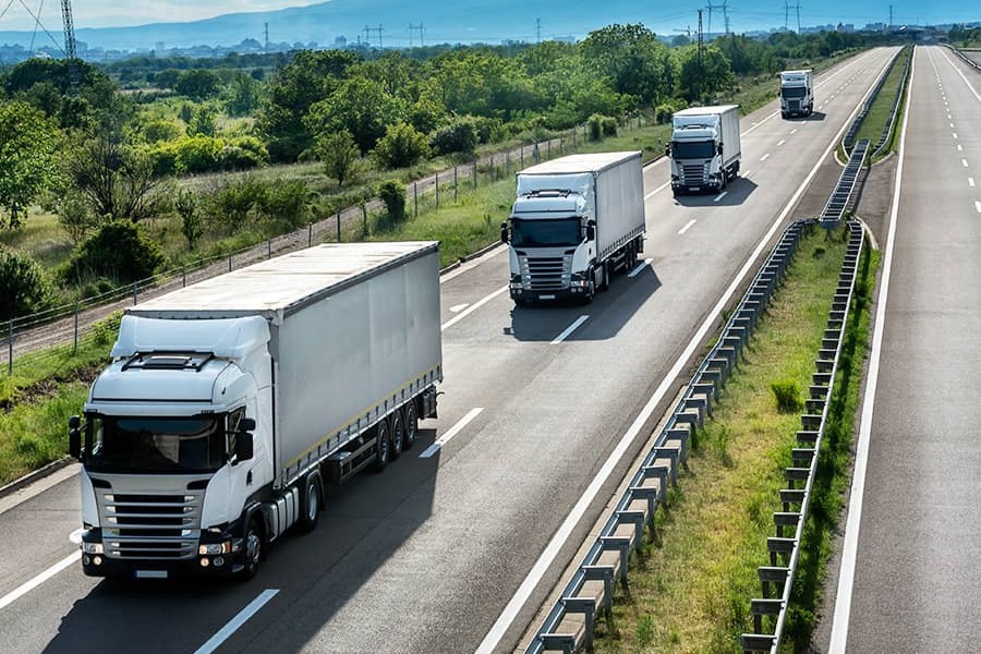 smart-fleet-dispatch-chapter2-900x600.jpg Four trucks travelling in convoy down a road.