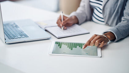 Businesswoman analyzing graphs on a tablet