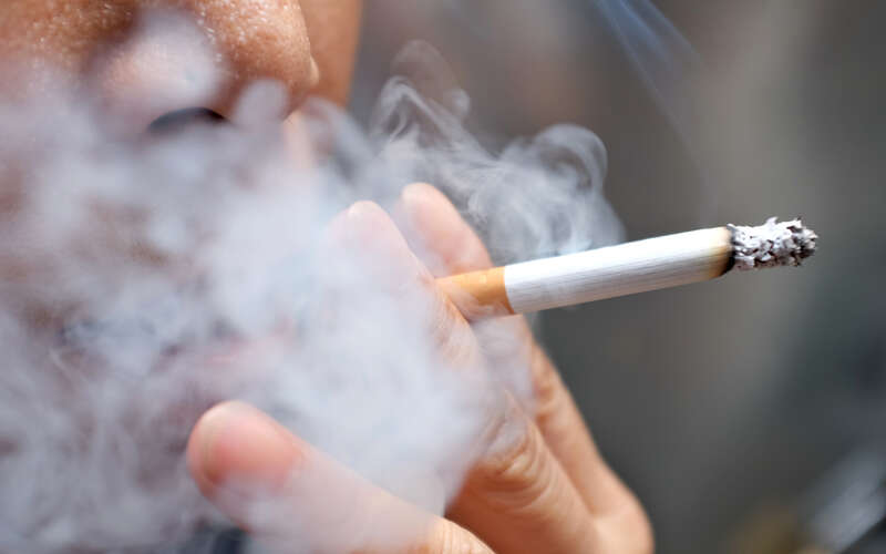 images of someone holding cigarette to their mouth