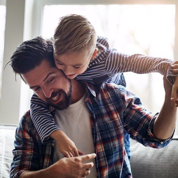 son on father's shoulders playing around