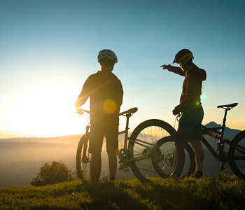 Turna kolesarja na gorski poti STKP s pogledom na slovensko pokrajino v ozadju.