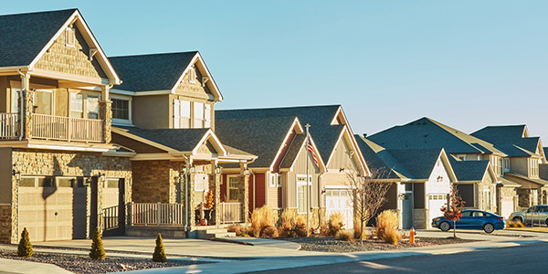 Row of neutral colored neighborhood homes made of brick and vinyl 