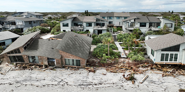 Damaged neighborhood homes with siding blown off of the houses