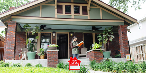 woman going over details in front a house for sale