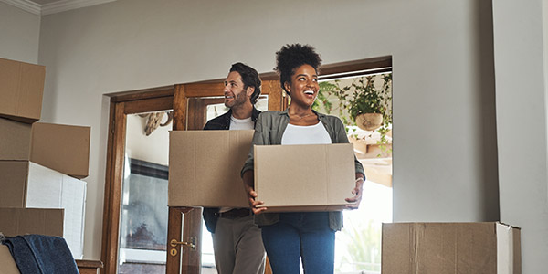 couple moving boxes into their new home