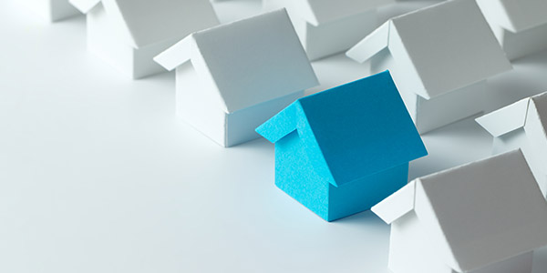 Several small paper models of houses sit on a table top