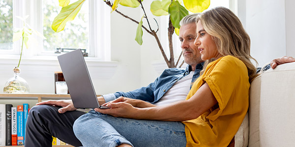 couple on the couch with their laptop