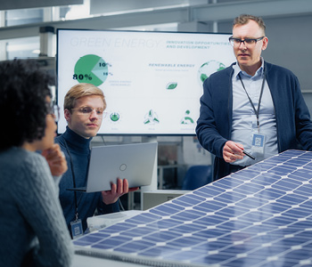 Ekipa v tehnološkem podjetju na sestanku - simbolna fotografija za trajnostni razvoj in njegove koristi za podjetja in zaposlene