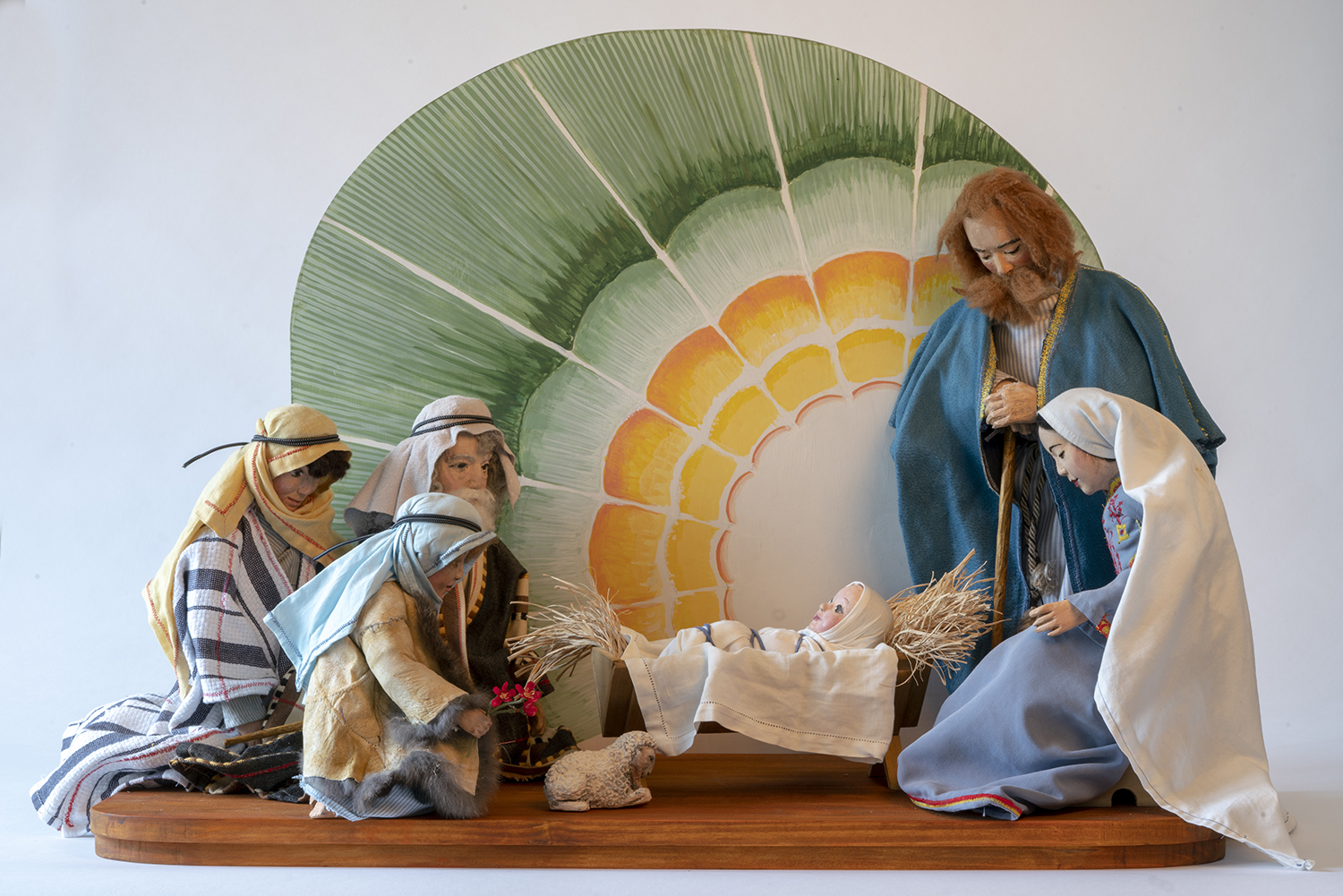 Nativity scene “Adoration of the Shepherds” by Nancy Schnarr-Bruell (figures) and John Bruell (backdrop) which includes the Holy Family and shepherds.