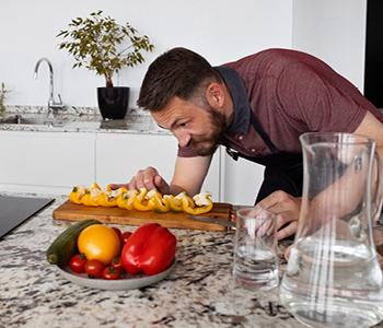 Mlad tekač v kuhinji pripravlja zelenjavo za malico