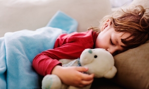 Vročinski krči pri dečku so minili – kljub vročini spi v postelji.