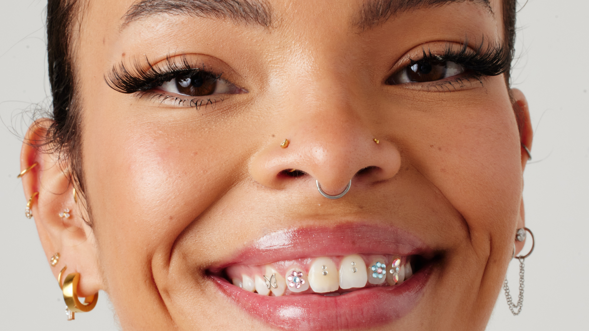 Close up of girls face with nose piercings and ear piercings