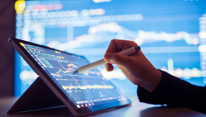 Woman looking stock market data on smart tablet