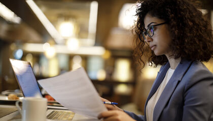 Business woman reading with laptop in cafe