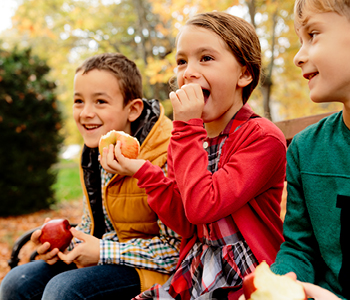 Otroci uživajo v zdravi malici, ki je del uravnotežene prehrane in zdrave rutine.
