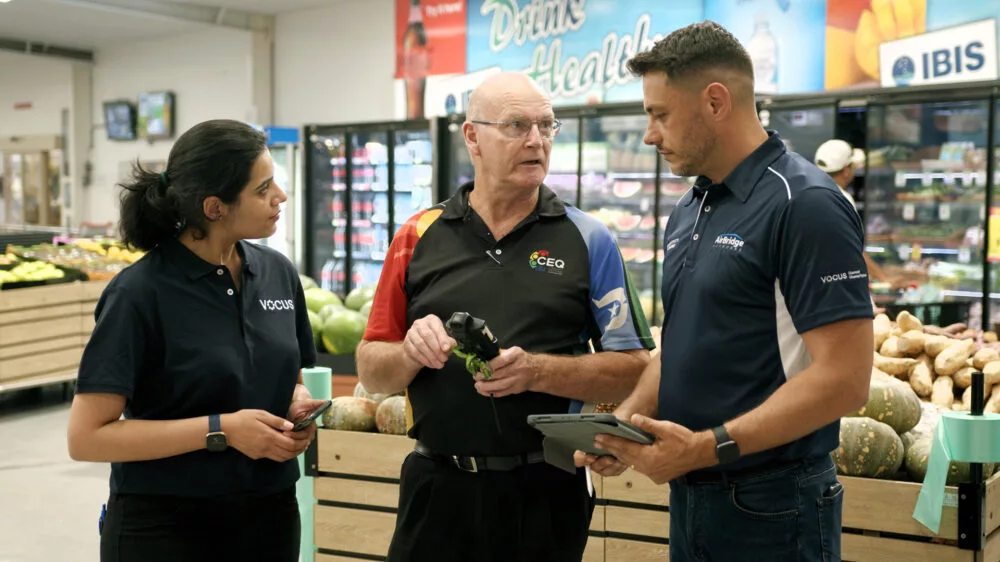 Photo of Vocus and CEQ workers talking at a supermarket