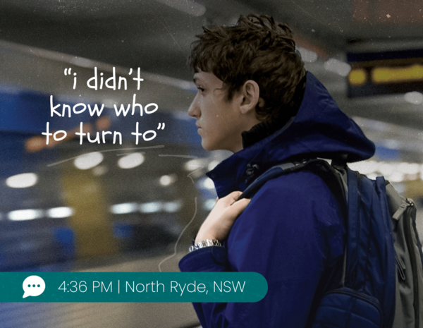 Boy standing at a train station looking at a passing train