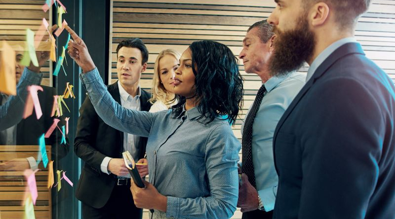 People working and collaborating together in front of a white board to showcase Materion partnership with customers